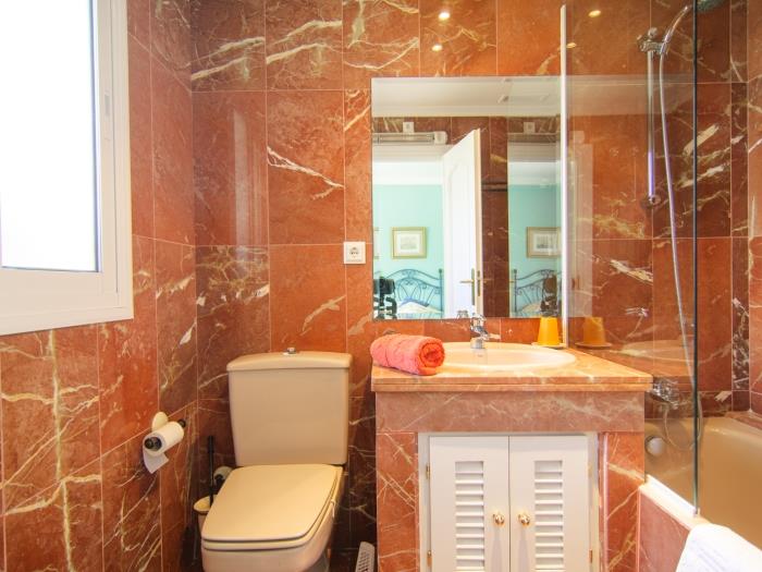 En suite bathroom with bathtub with shower, sink