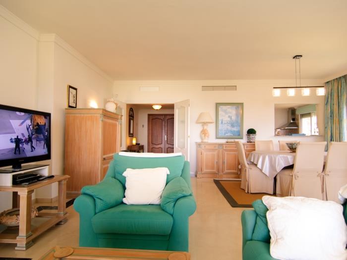 Armchairs and sofas in front of flat screen TV