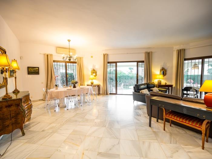 Lounge area with two sofas, armchairs and TV