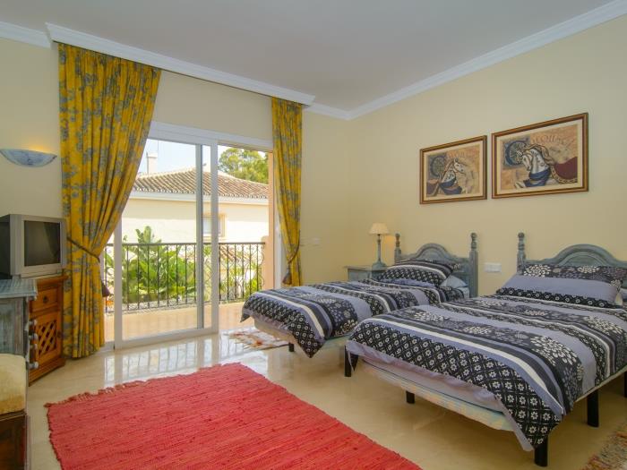 Guest bedroom w/ two single beds, exit to terrace