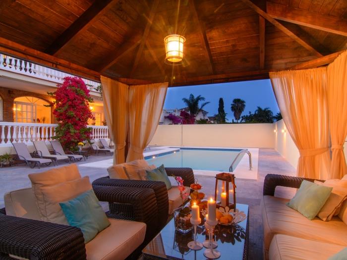 Pergola with comfortable rattan sofa and armchairs