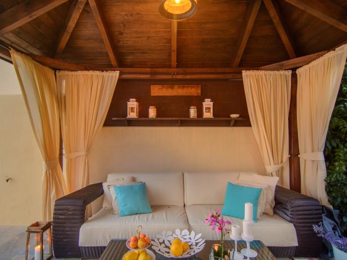 Comfortable rattan sofa and armchairs in pergola
