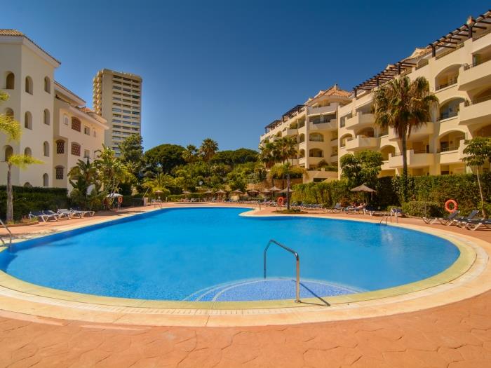 Spacious swimming pool surrounded by sun loungers