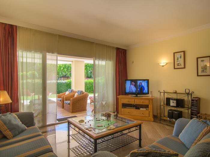 Lounge area with sofas, glass table, TV and view
