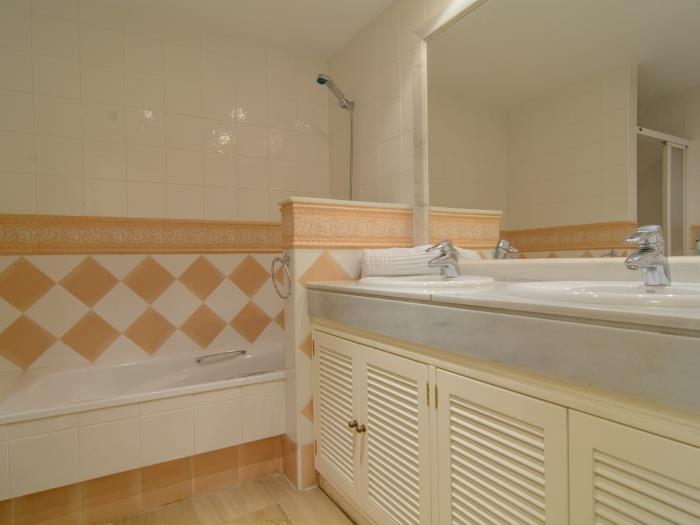 En suite bathroom with double sink, bathtub, bidet
