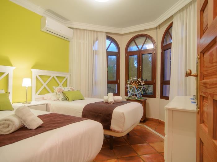 Two single beds in guest bedroom, large windows