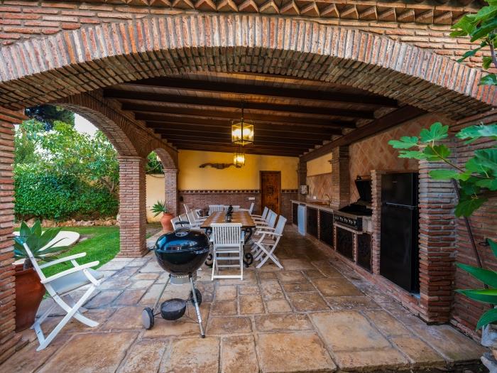 Barbecue area with dining table, kitchen counter