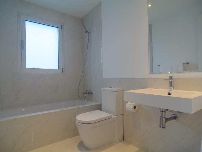 Bathtub with shower, sink and toilet in bathroom
