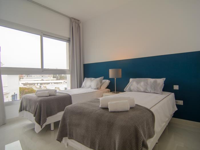 Guest bedroom with large windows and two beds