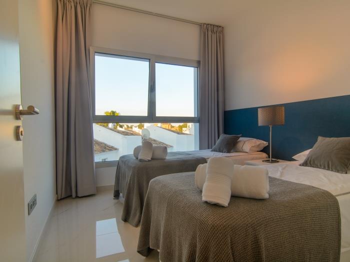 Two single beds in guest bedroom with nightstand