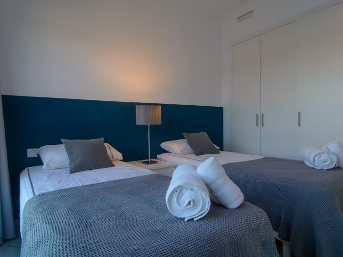 Nightstand with lamp between two single beds