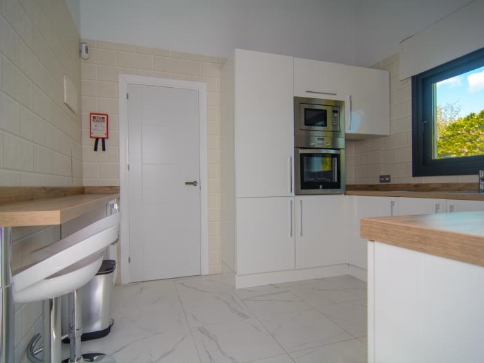 Kitchen with bar stools, refrigerator, microwave, vitro ceramic, refrigerator, kettle