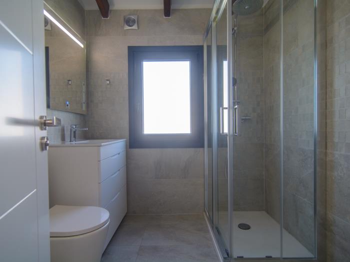 Family bathroom with walk in shower, sink, toilet and window