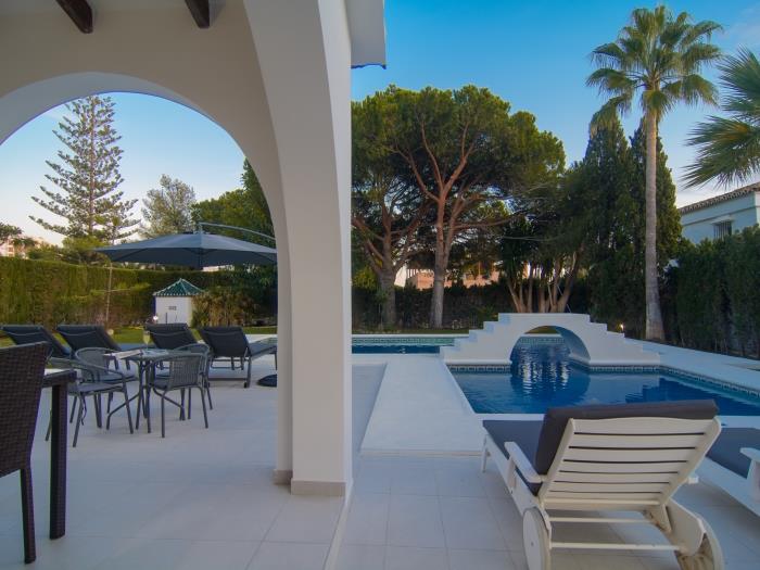 Exotic vegetation in private garden with pool and sun loungers