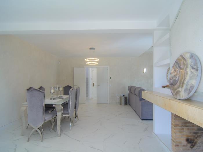 Living room with dining area, elegant table for six with upholstered chairs , fireplace
