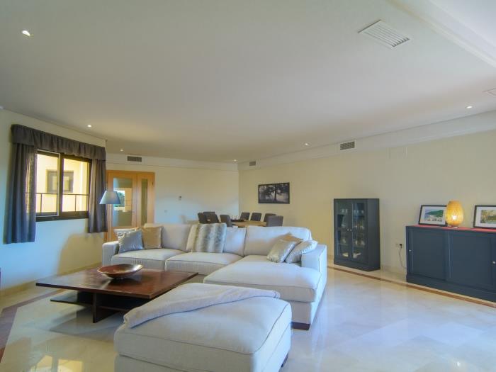 Living room with sitting area, wooden table and comfortable sofa