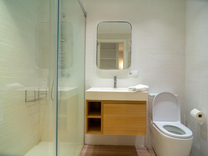 En suite bathroom with walk-in shower, sink, toilet, rain head shower
