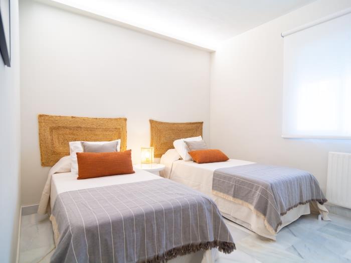 Bedroom with two single beds and nightstand with a lamp
