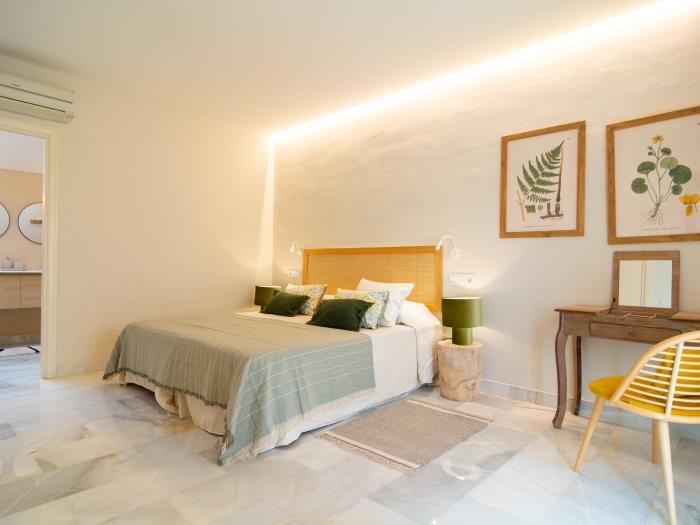 The bedroom on the upper level of the apartment has a delicate color palette