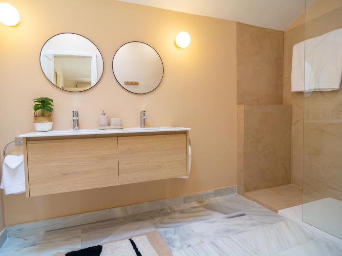 En suite bathroom with walk-in shower, double sink, rain-head shower, toilet