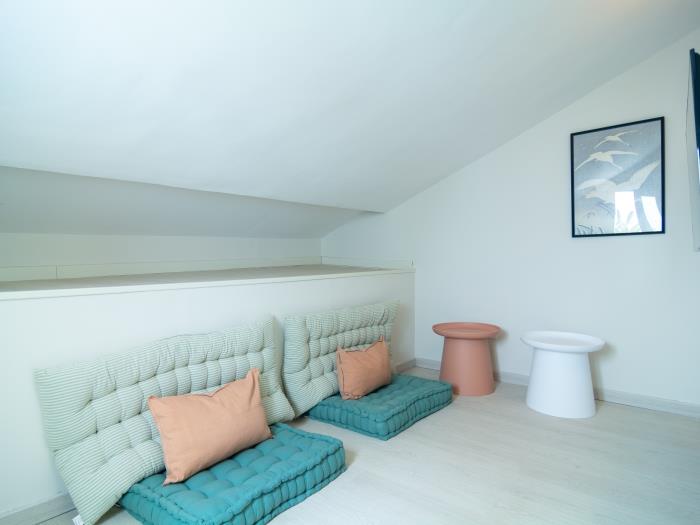 Small hobby room for youth with cushions and flat-screen TV