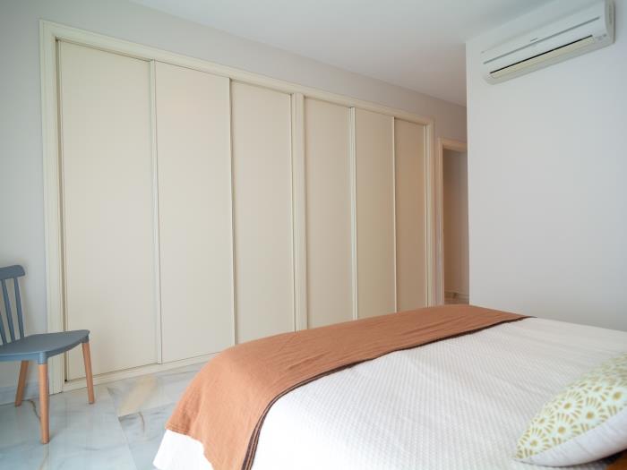Recessed wardrobes, air conditioner, double bed in bedroom on upper level