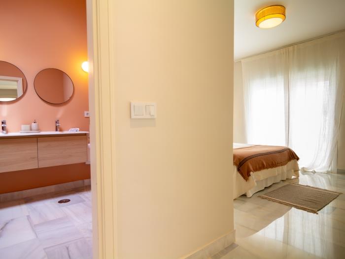Family bathroom with walk-in shower, double sink, toilet, skylight