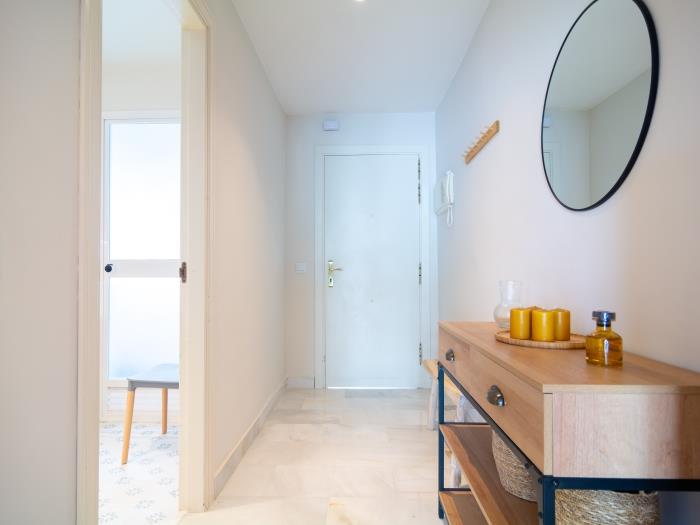Small entry hall with a wooden bench, mirror, chest of drawers